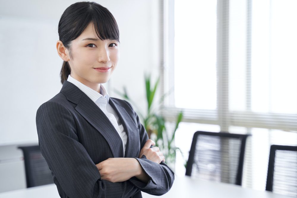 A Japanese woman in her office with her arms folded