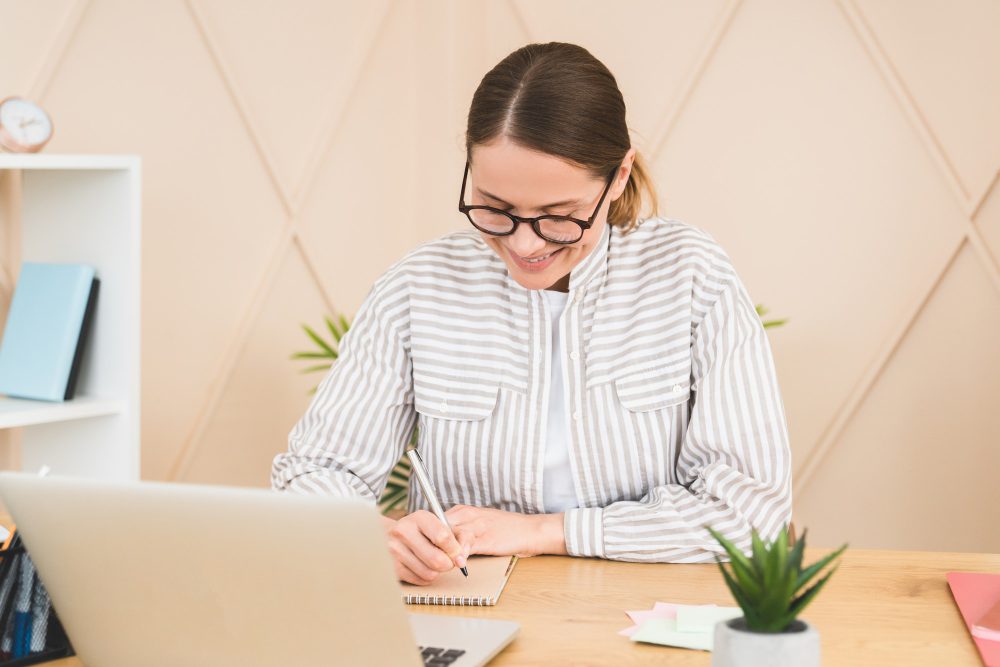 Businesswoman teacher tutor headmaster working on laptop writing projects planning startup in office
