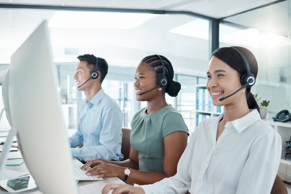 Call center, telemarketing or customer support consultants working on computer in a modern office.