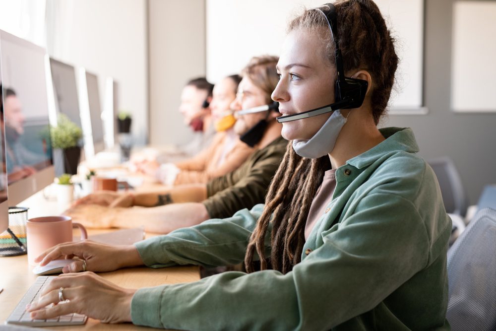 Customer support representatives with headsets looking at computer screens