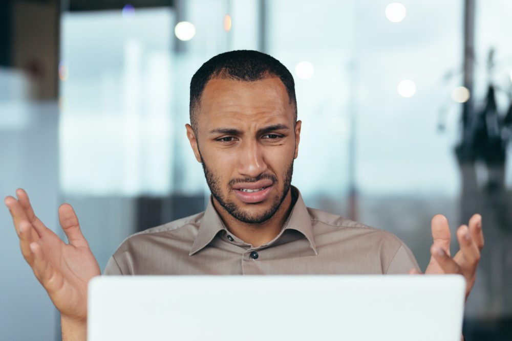 Upset businessman close up looking at laptop screen at work, man unhappy with received email